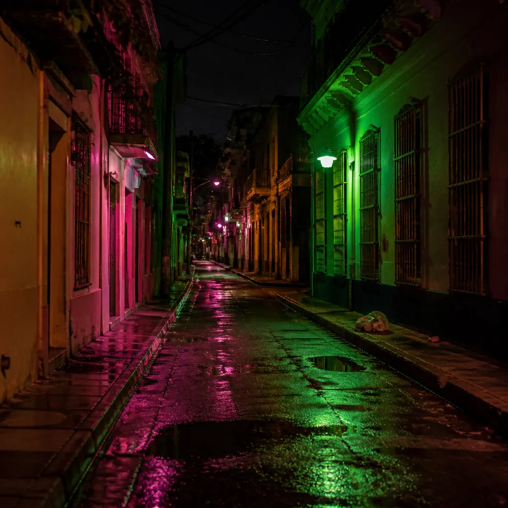 Callejón urbano de noche con reflejos de neón